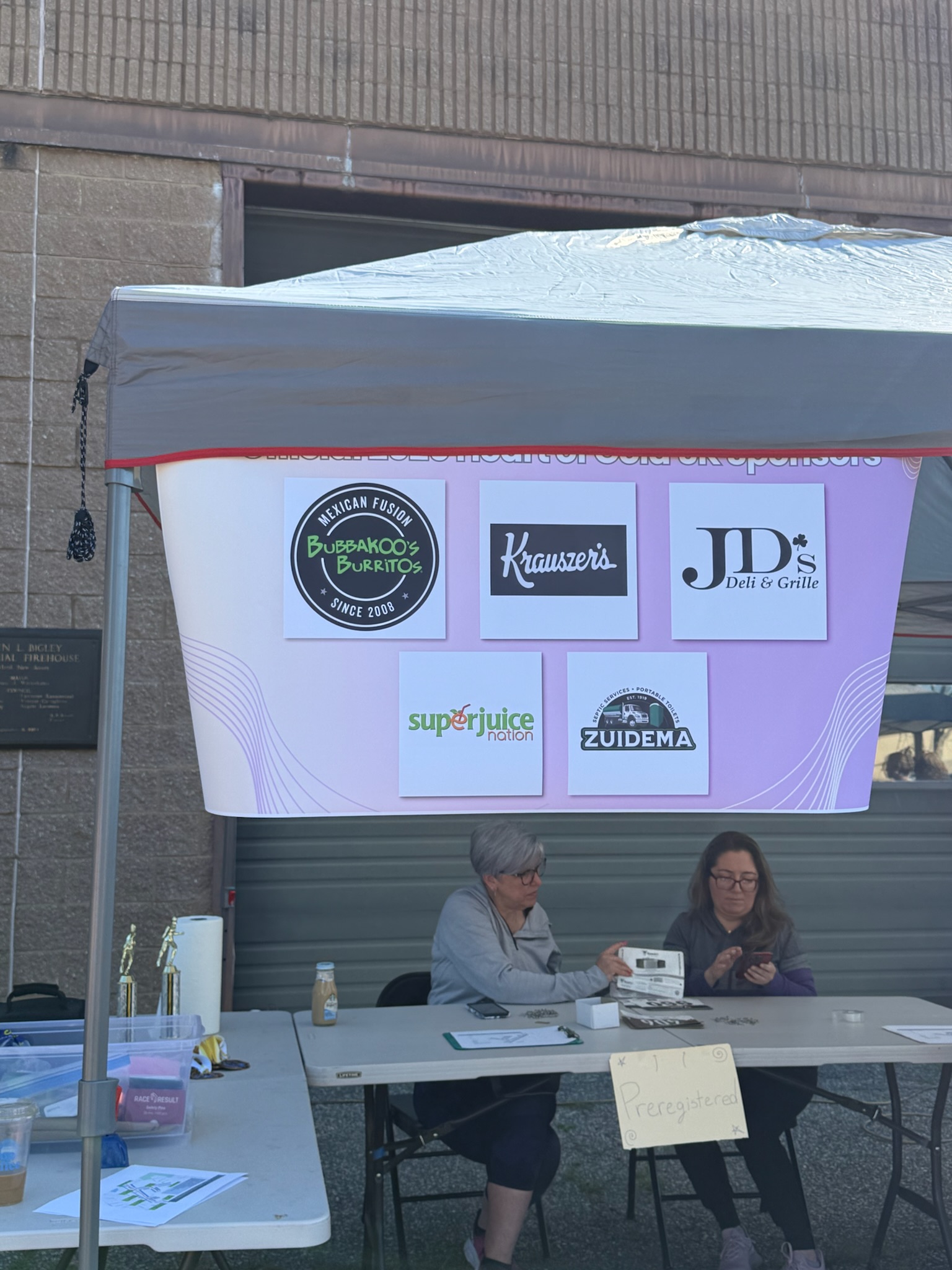 Race-day sponsor board displaying local business logos at the Heart of Gold 5K.
